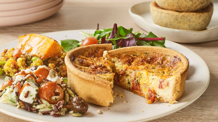 A quiche served on a plate with salad
